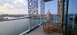 a balcony with two chairs and a view of the water at almoaj ,juman 2 marina view,level3 in Muscat