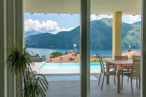 a dining room with a table and a view of the water at Villa Incanto in Mezzegra