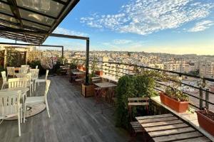 a balcony with tables and chairs and a view of a city at Azmal Hotel & Suites in Irbid