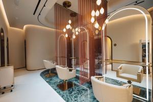 spogliatoio con sedie e specchio di The Muse a Doha