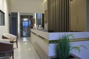 a lobby with a counter with a plant in the middle at Azmal Hotel & Suites in Irbid
