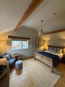 a bedroom with a bed and a couch and a window at The Red Lion Inn Alnmouth in Alnmouth