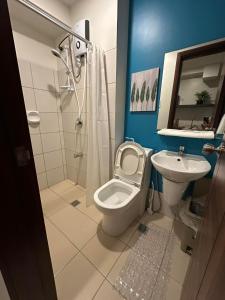 une salle de bain avec toilettes et lavabo dans l'établissement Horizons 101 Condotel, à Cebu