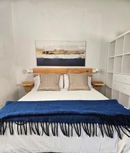 a bedroom with a bed with a blue blanket at La Casita de Don Honorio in Candelaria