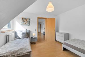 a bedroom with two beds and a hallway at 24-7 Living - Unna Central City Apartments in Unna