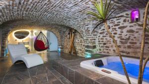 a room with a bath tub and a palm tree at La reine d'Orel - Jacuzzi privé in Besançon
