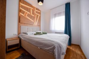 a bedroom with a large bed with a wooden headboard at Gorski Elegance 2 in Zlatibor