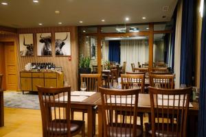 Un comedor con mesas y sillas de madera. en The Lodge Hotel, en Borovets 88 fotos más