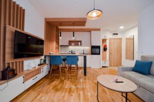 a kitchen and living room with a couch and a table at Gorski Elegance 2 in Zlatibor