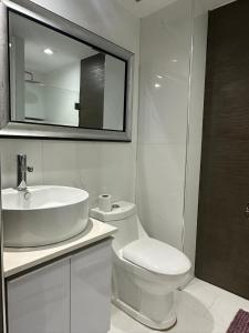 a bathroom with a sink and a toilet and a mirror at Apto Vip acceso a la playa in El Morro de Barcelona