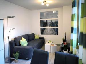 a living room with a blue couch and a window at Haus Meeresblick - Ferienwohnung Am Strand (Ref. 128682u1) in Baabe