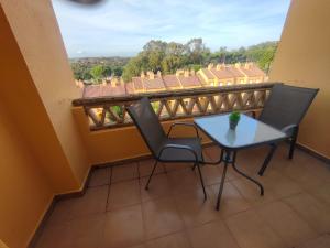 a table and chairs on a balcony with a view at La casa del verano in Isla Cristina