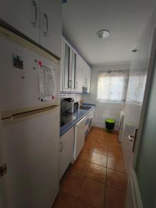 a kitchen with white cabinets and a tile floor at La casa del verano in Isla Cristina