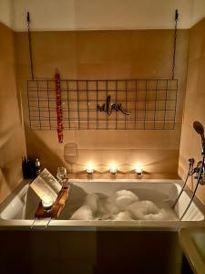 a bath tub with candles and towels in it at Orange byt s parkovacím místem v centru města in České Budějovice