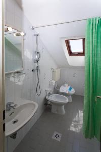 a bathroom with a sink and a toilet and a mirror at Hotel Romantik & Depandance in Lignano Sabbiadoro +89 photos