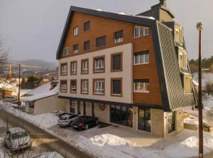 a large building with cars parked in a parking lot at WILD BEAUTY Apartment-Modern mountain 2 in Kolašin