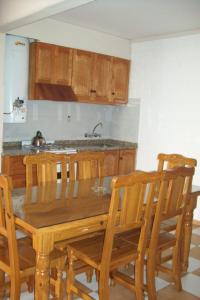 a kitchen with a wooden table and wooden chairs at Muras Apart Hotel in Mendoza