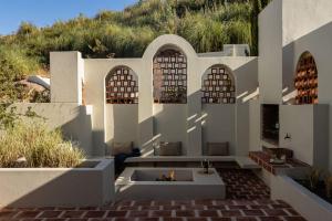 a house with a fireplace in the middle of a courtyard at Spioenkop Wines Farm House in Elgin