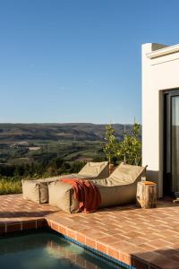 a couch sitting on a patio next to a pool at Spioenkop Wines Farm House in Elgin