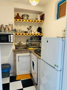 Una cocina con un frigorífico blanco y un lavavajillas. en Dar Beldi, en Marrakech