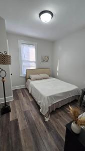 a white bedroom with a large bed and a window at Serenity Haven in Irvington