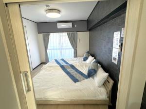 une chambre avec un grand lit avec un mur de briques dans l'établissement K2 square 903, à Nagoya