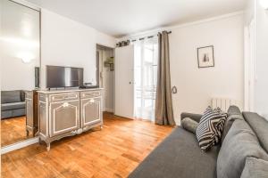 a living room with a couch and a flat screen tv at Levis Charming Place in Paris