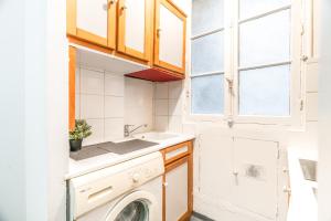 a small kitchen with a sink and a washing machine at Levis Charming Place in Paris +13 photos