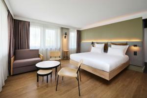 a hotel room with a bed and a table and a chair at Moxy Annecy in Annecy