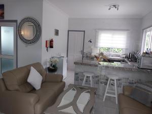 a living room with a couch and a kitchen at Agnes Cottage in La Réunion