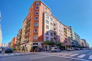 ein hohes rotes Backsteingebäude in einer Stadtstraße in der Unterkunft El Encanto de Huesca by Clabao in Logroño