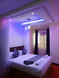 a bedroom with a large bed with purple lighting at The Grand Alton Resort in Kisumu