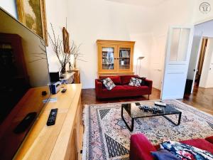 TV a/nebo společenská místnost v ubytování Gîte paisible avec jardin privatif et terrasse, 2 chambres, proche sites culturels, animaux acceptés - FR-1-510-174