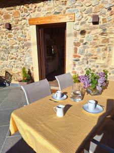 a table with a yellow table cloth on a stone wall at El Molino de Nocedo in León