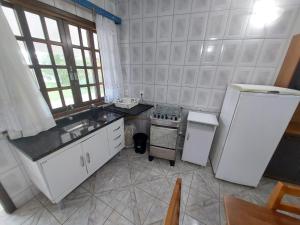 a kitchen with a white refrigerator and a sink at Beira Mar Pontal do Sul in Pontal do Paraná