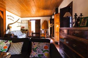 ein Wohnzimmer mit einem Sofa und einer Holzdecke in der Unterkunft Casa rural con barbacoa y piscina in Ríogordo