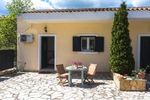 a patio with a table and chairs in front of a house at Sunny Patio Studio Corfu ! in Alepou