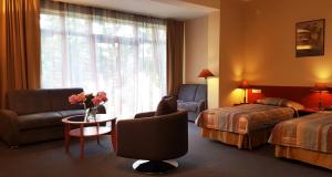 a hotel room with a bed and a couch and a table at Perkuno Namai Park Hotel in Kaunas +33 photos