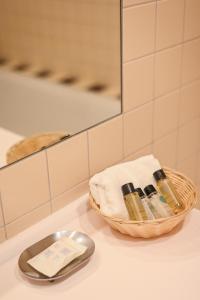 a bathroom counter with a basket of soap and a mirror at Perkuno Namai Park Hotel in Kaunas