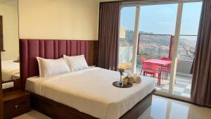 潘奇加尼2BHK Suite, Panchgani Views, Ora Vue的一间带床的卧室和一个带桌子的阳台