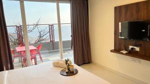 潘奇加尼2BHK Suite, Panchgani Views, Ora Vue的酒店客房设有一张床,享有阳台的景色