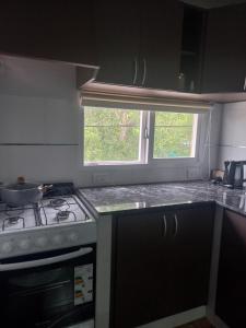 a kitchen with a stove and a sink and a window at Paramecó in Balneario Claromecó