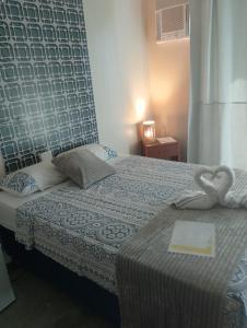 a hotel room with a bed with a heart shaped towel at Paradise Beach in Fortim