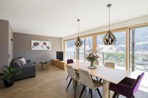 a dining room and living room with a table and chairs at Residence Sonja in Rablà