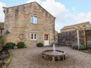 a stone house with a fountain in front of it at The Old Cobblers in Skipton