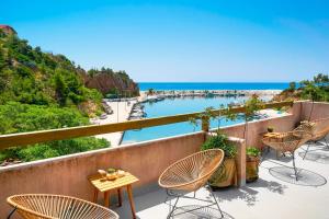 リメナリアにあるAnasa Thalassasの椅子とビーチの景色が見えるバルコニー