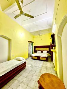 a bedroom with two beds and a ceiling fan at Crystal Cottage in Ayodhya
