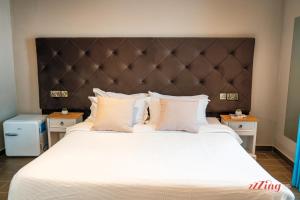a bedroom with a large bed with white sheets and pillows at The Segond Hotel in Xagħra