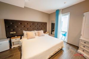 a bedroom with a large bed and a large window at The Segond Hotel in Xagħra