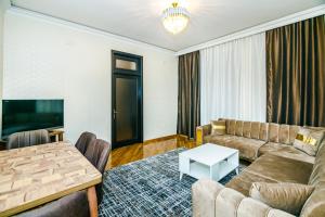a living room with a couch and a table at Apartment BİCOCCA in Baku